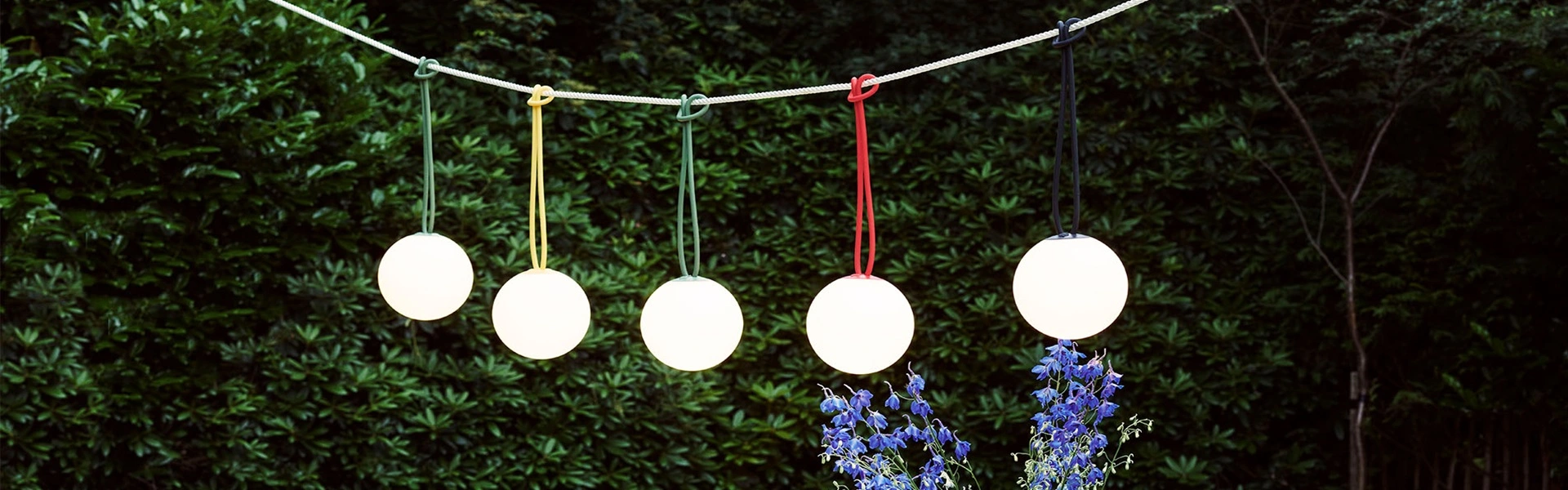 Fatboy Bolleke lampen in verschillende kleuren, hangend aan een touw buiten