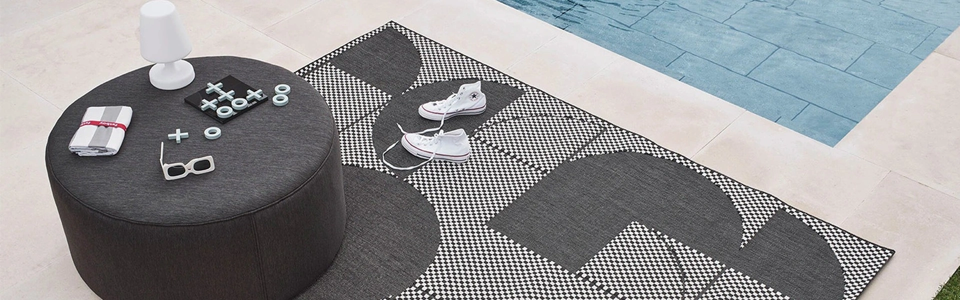 Fatboy buiten poef bij een zwembad met decoratieve items en een kleed