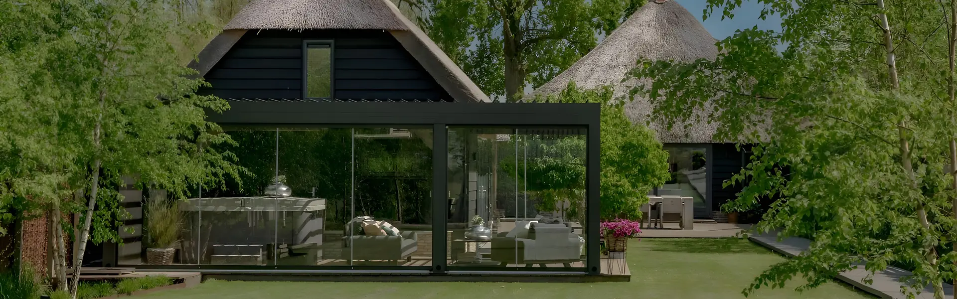 Glisse glazenschuifwanden in een landelijke setting bij een rietgedekte woning