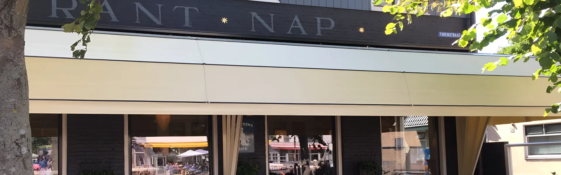 Horecapand met witte markiezen en historische gevel