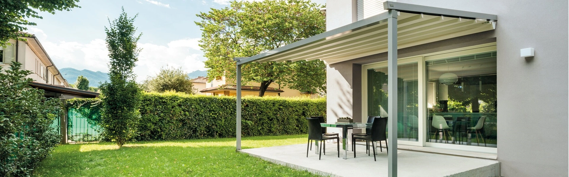 Jeans schuine overkapping met terras in groene tuin