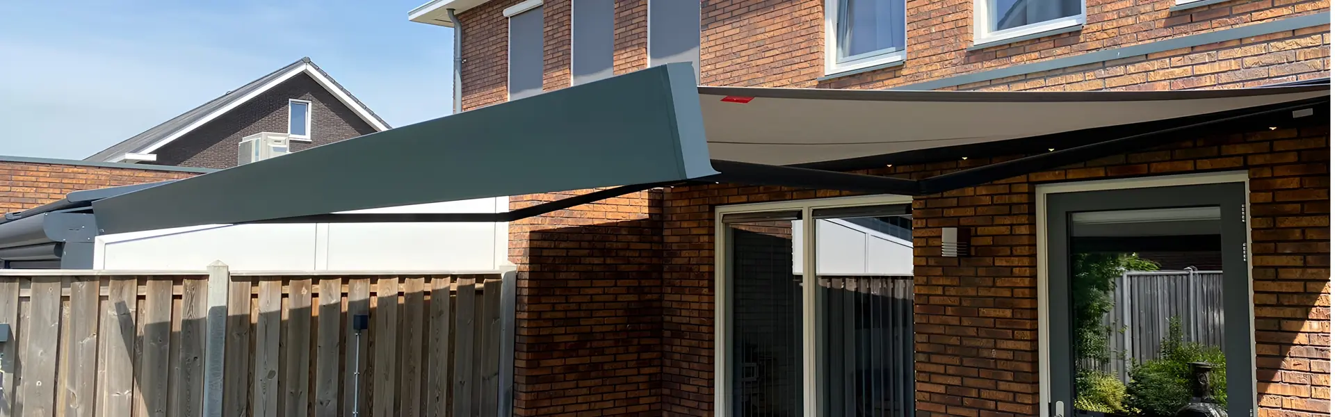 Knikarmscherm in open stand boven een terras met tuinmeubilair