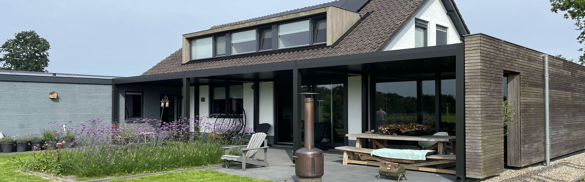 Lamellen overkapping Varia met bloemen en zithoek in achtertuin