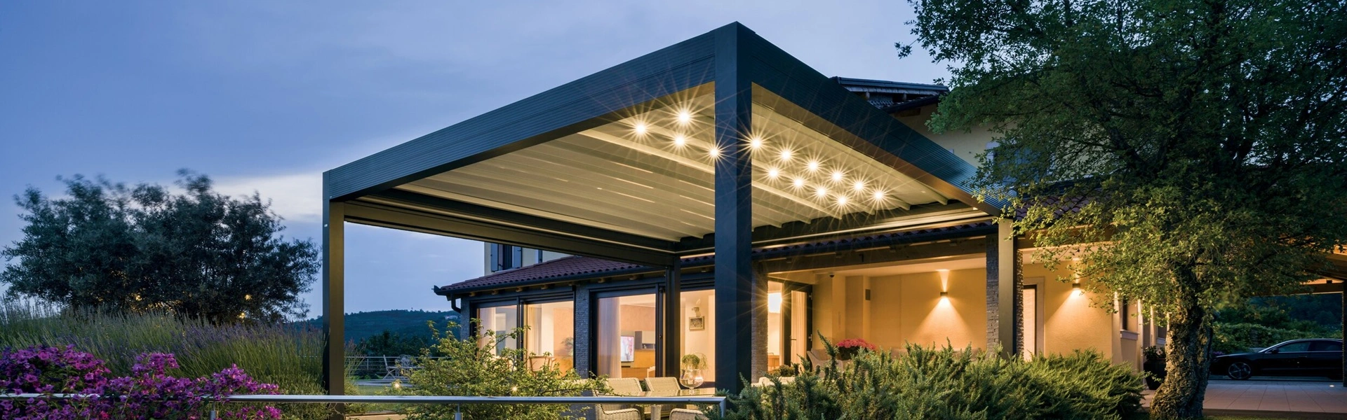 Ledspots in een buitenoverkapping bij zonsondergang voor extra ambiance