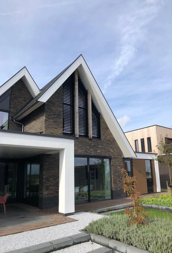Louvre lamellen op moderne woning in Meerstad, Veldman Zonwering Louvre lamellen op een bakstenen woning voor zonwering en privacy