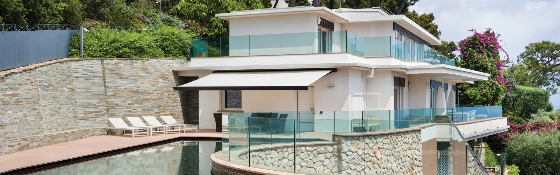 Luxe knikarmscherm Nodo boven een zwembad en terras bij villa