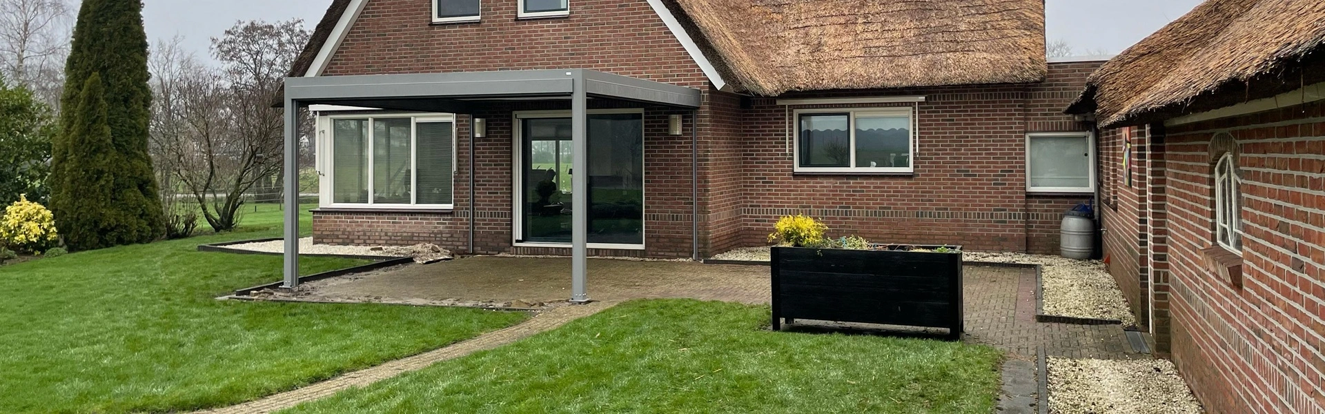 Moderne Qbus overkapping met strakke lijnen en zonwering in landelijke omgeving