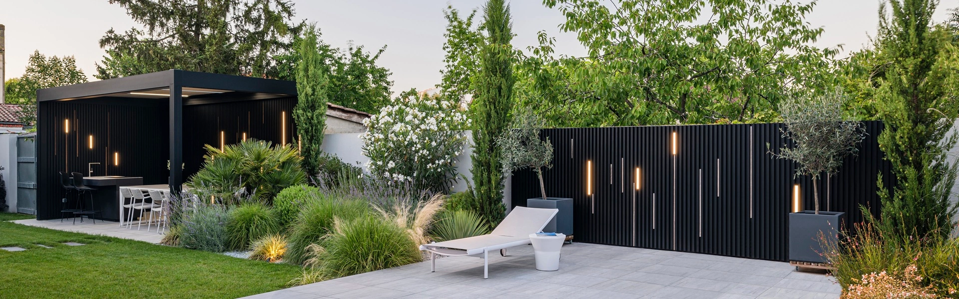 Moderne tuin met Renson Camargue buitenkeuken en sfeerverlichting