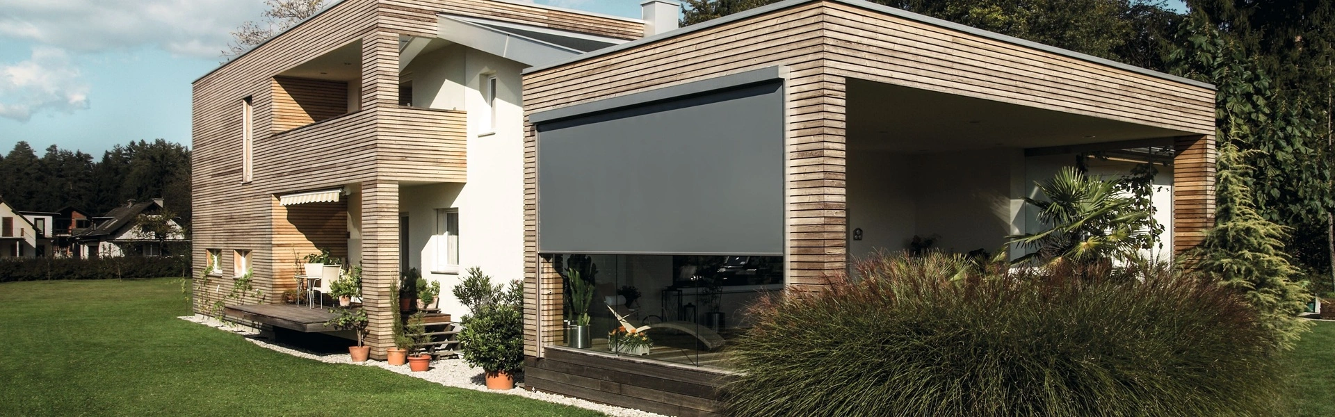 Moderne woning met houten gevel en grijze screens aan de buitenzijde