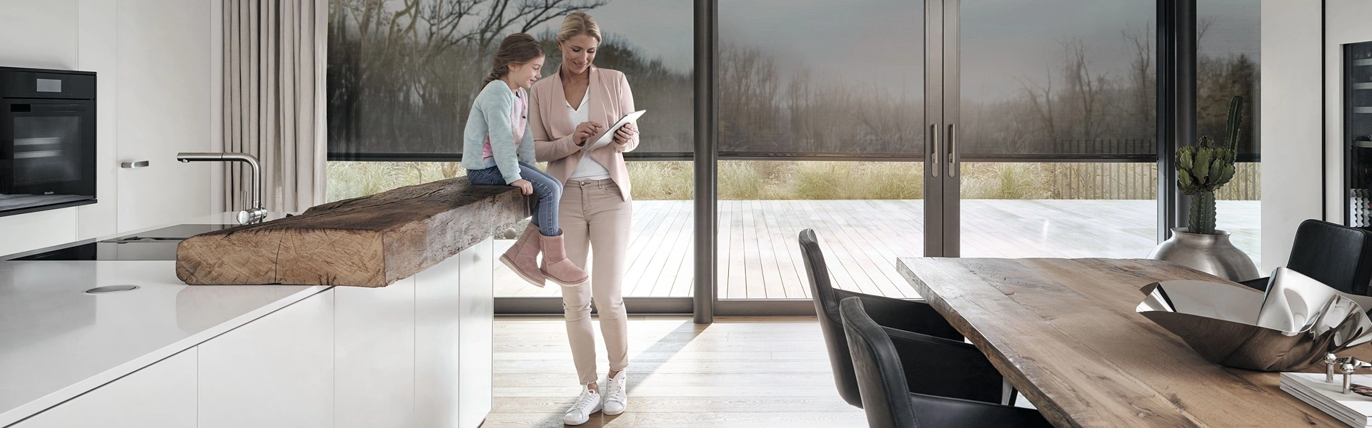 Moeder en dochter gebruiken domotica bij textielscreens in moderne keuken