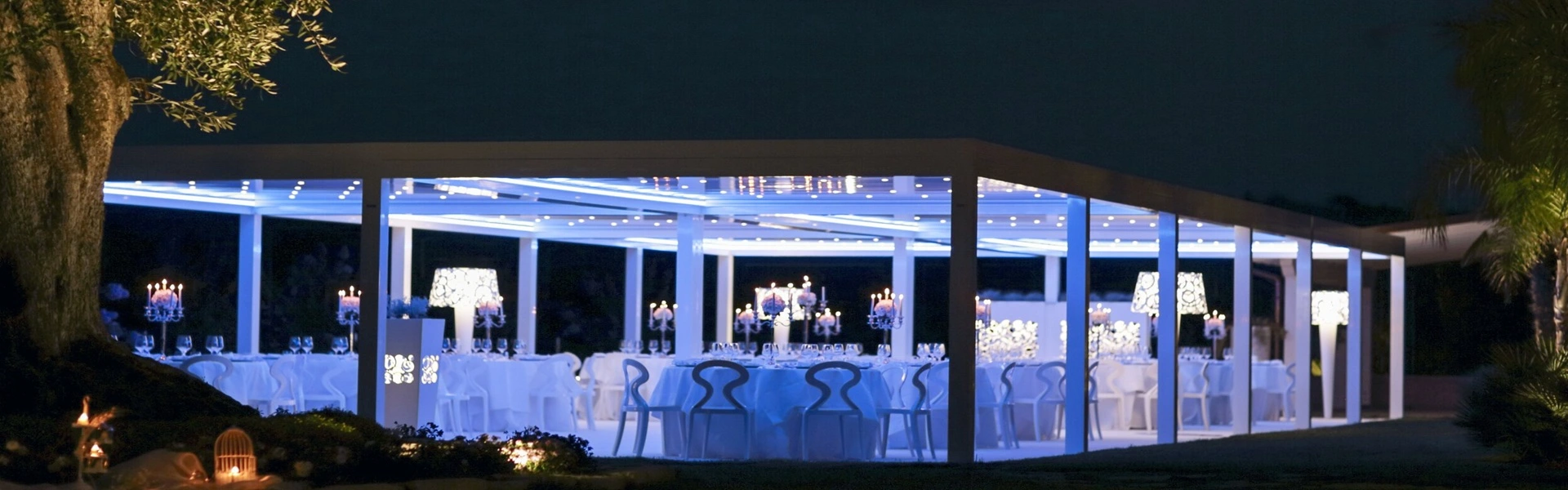 Nachtelijke setting met verlichte overkapping en elegante tafeldecoratie