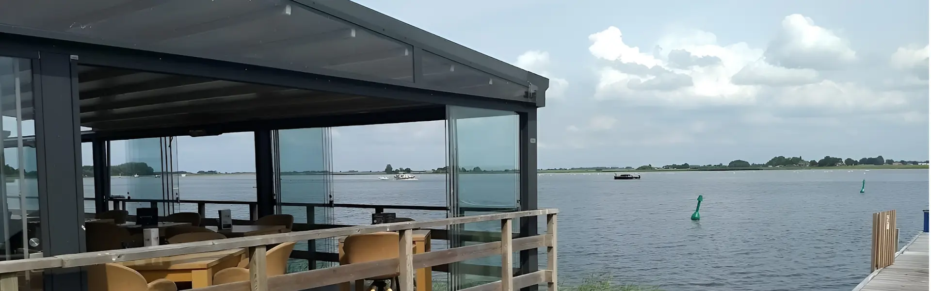 Overdekt terras met glazenschuifwanden aan het water
