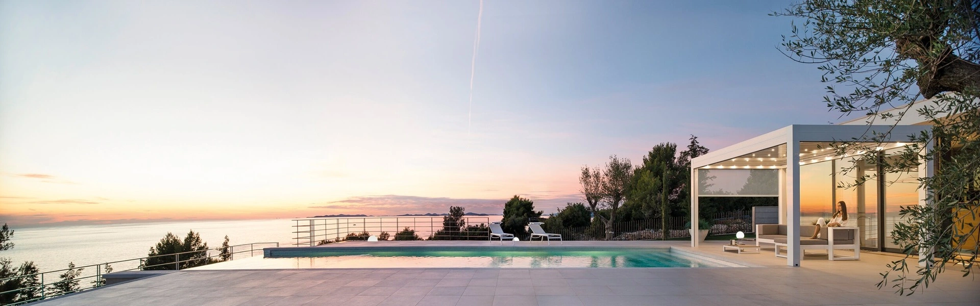 Overkapping met ledverlichting en uitzicht op zee bij zonsondergang