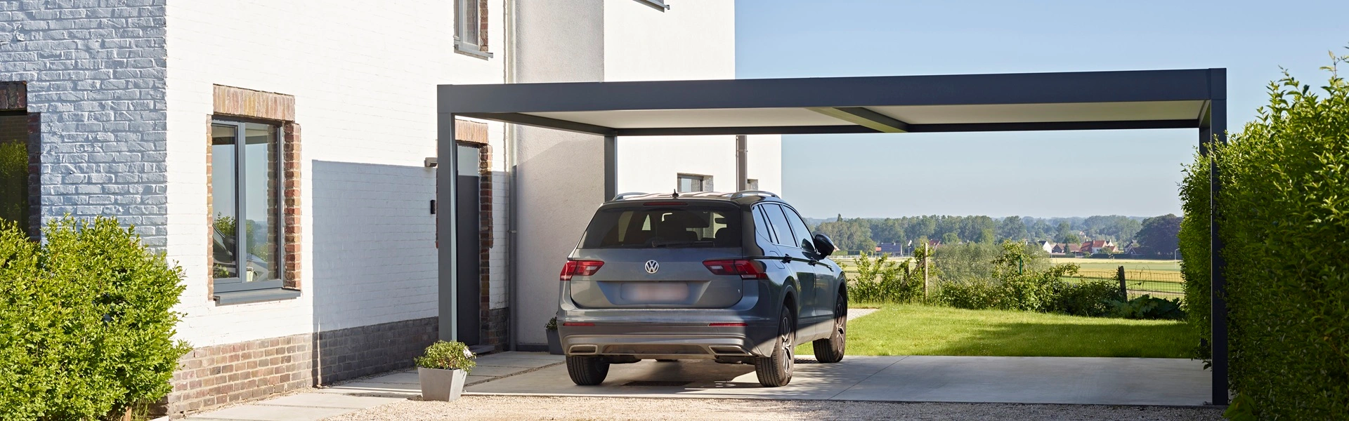 Renson Algarve Canvas carport naast witte woning met uitgestrekt uitzicht