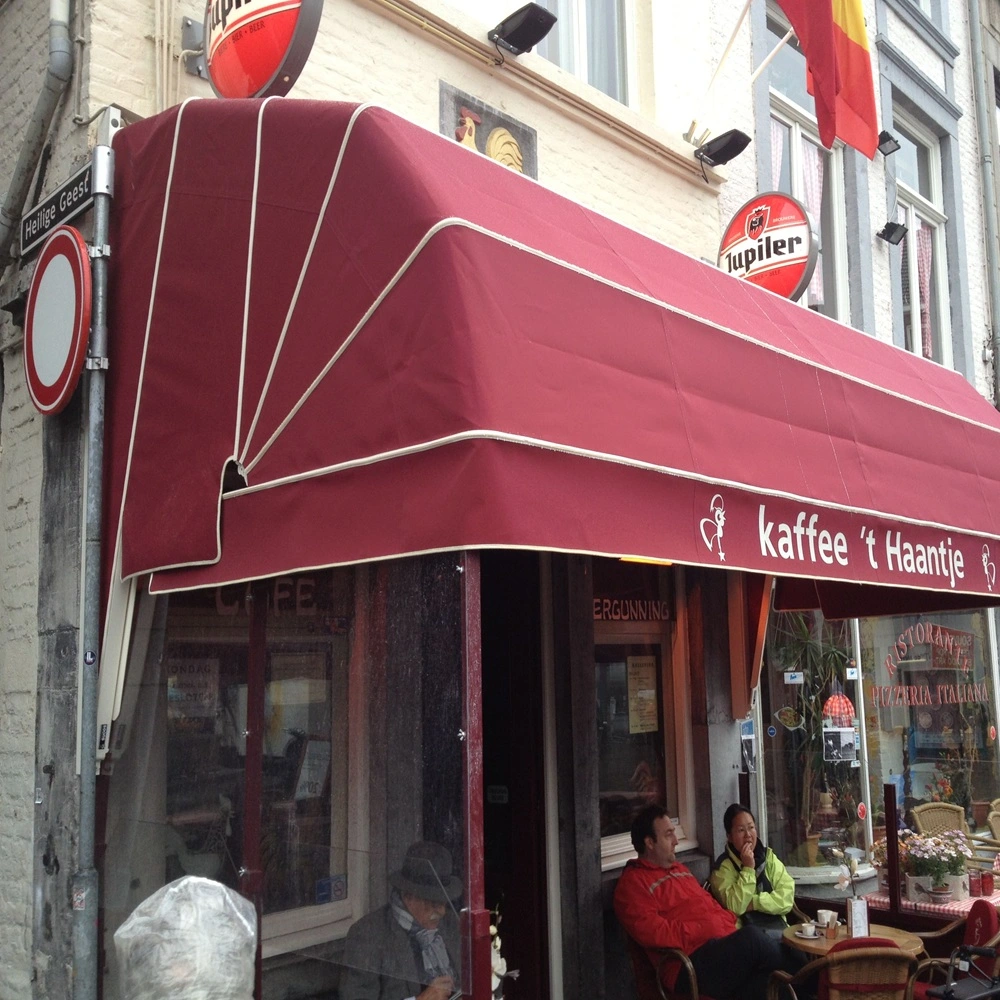 Rode petmodel markies met de tekst 'kaffee ’t Haantje' boven een cafe-ingang