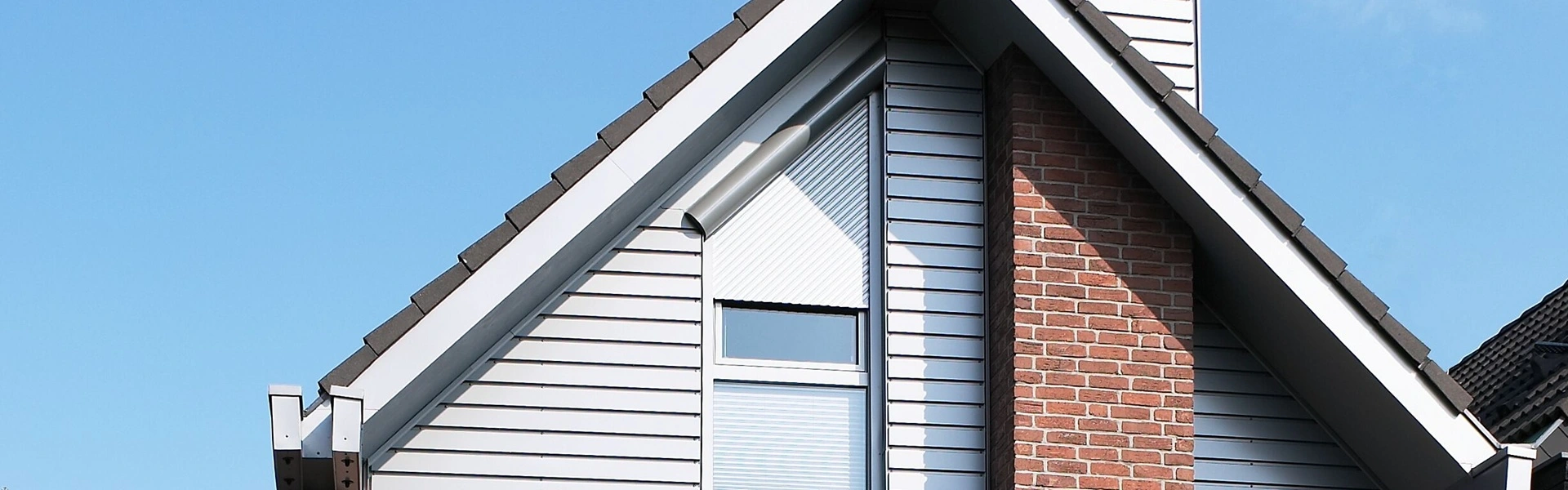Roma Trendo rolluik op schuin raam met houten en bakstenen gevel