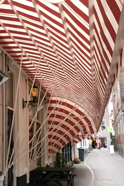 Rood-witte gestreepte markiezen met klassieke uitstraling boven een terras Rood-witte gestreepte markiezen met klassieke uitstraling boven een terras