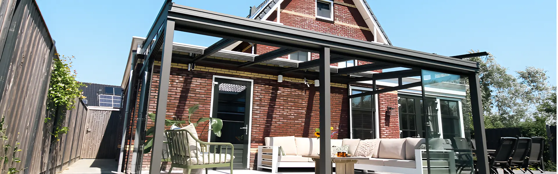 Schuine overkapping Classic met glazen schuifdak en loungeset in tuin