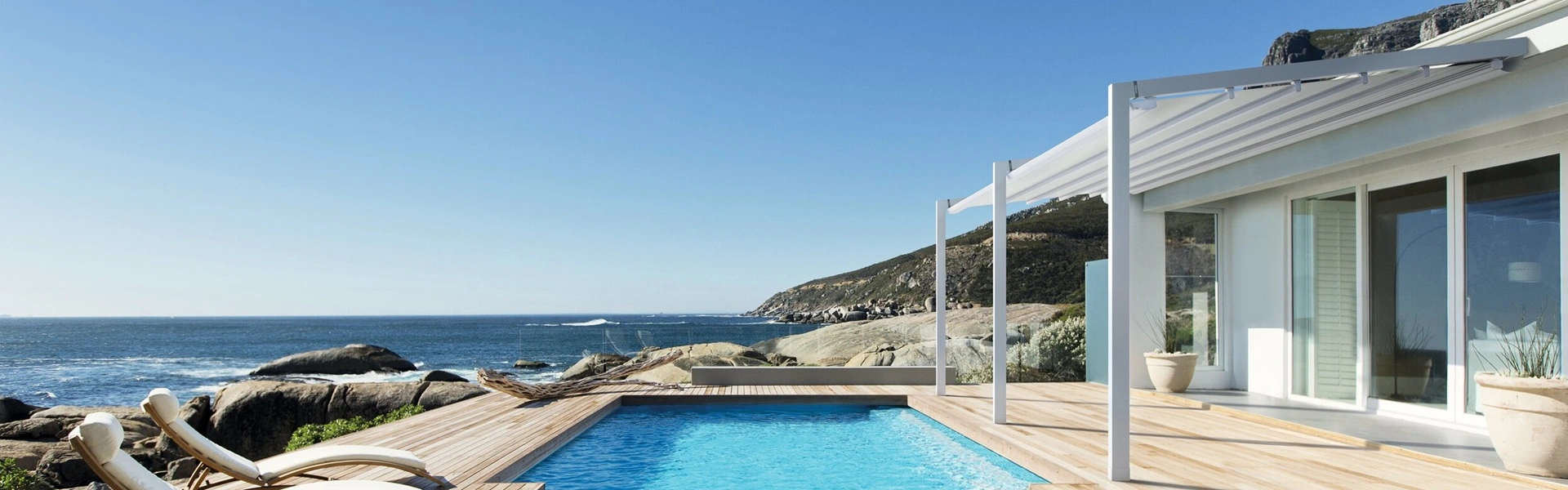 Schuine overkapping Luce met sfeerverlichting boven een terras bij een zwembad