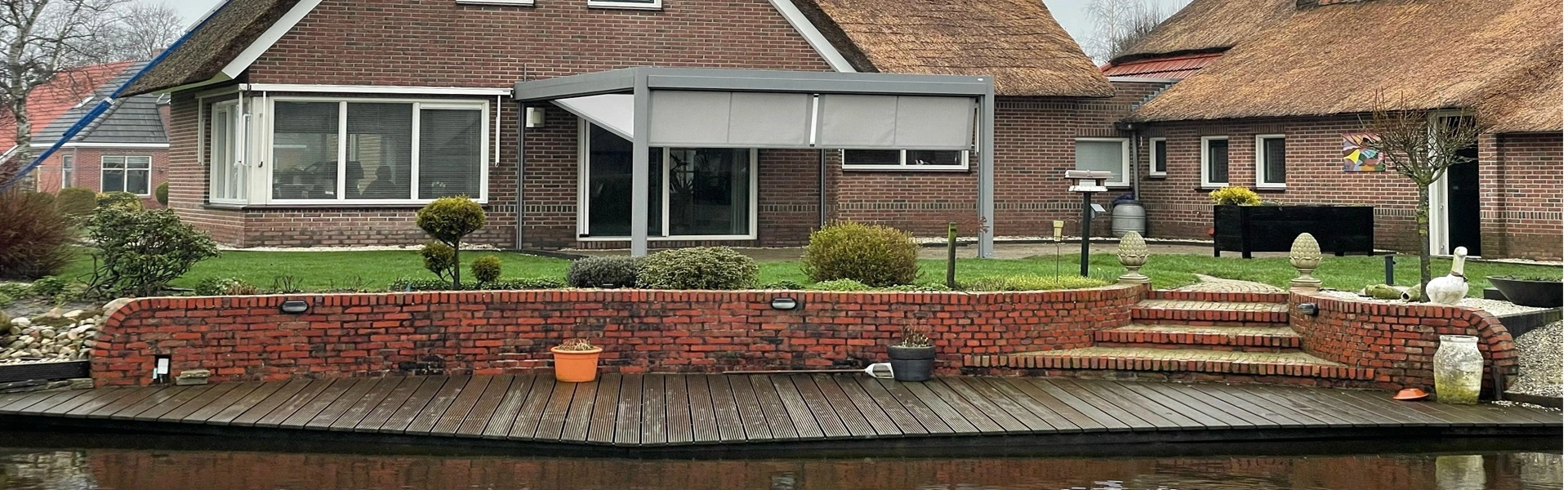 Terrasoverkapping Qbus met zonwering bij woning aan water