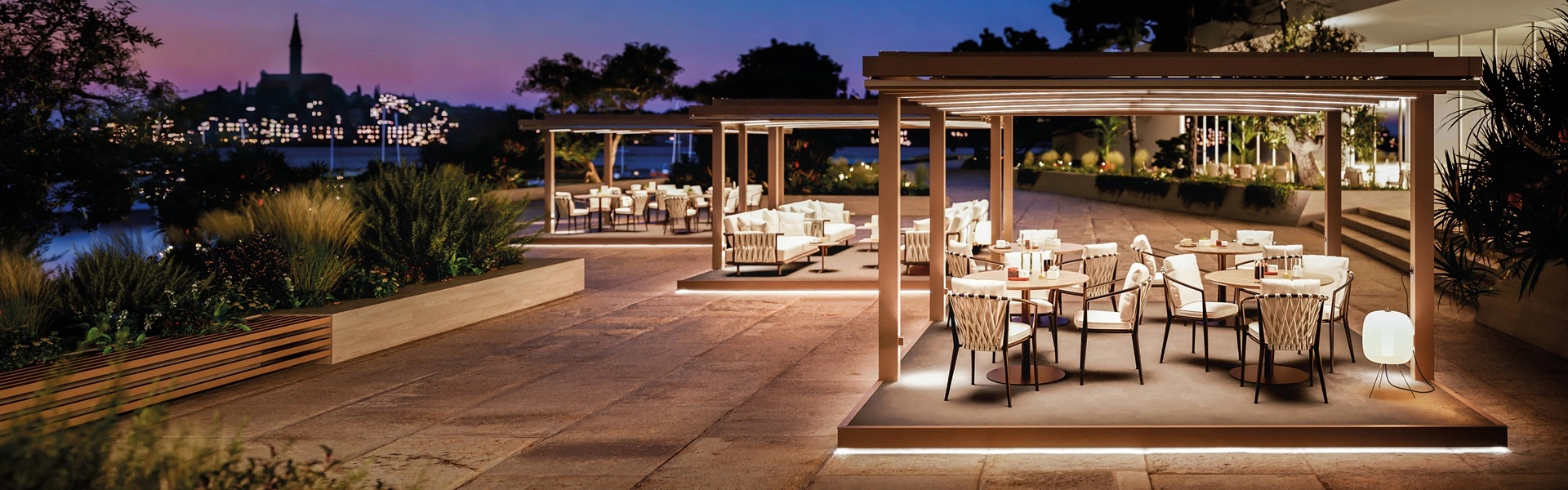 Tuinkamer Phoenix met sfeerverlichting bij zonsondergang aan het water