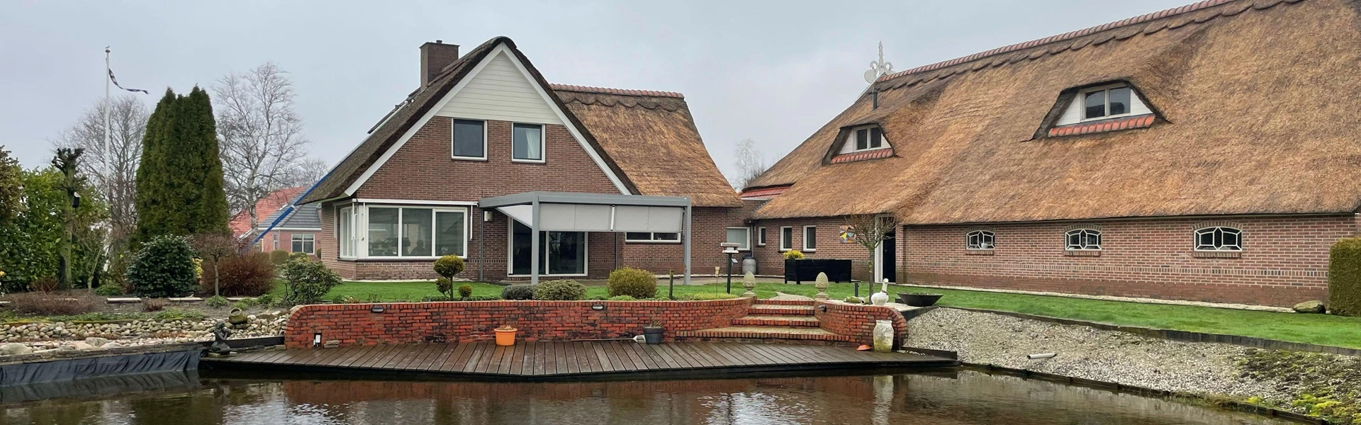 Veldman Zonwering terrasoverkapping bij rietgedekte woning aan het water in Ureterp Veldman Zonwering terrasoverkapping bij rietgedekte woning aan het water in Ureterp