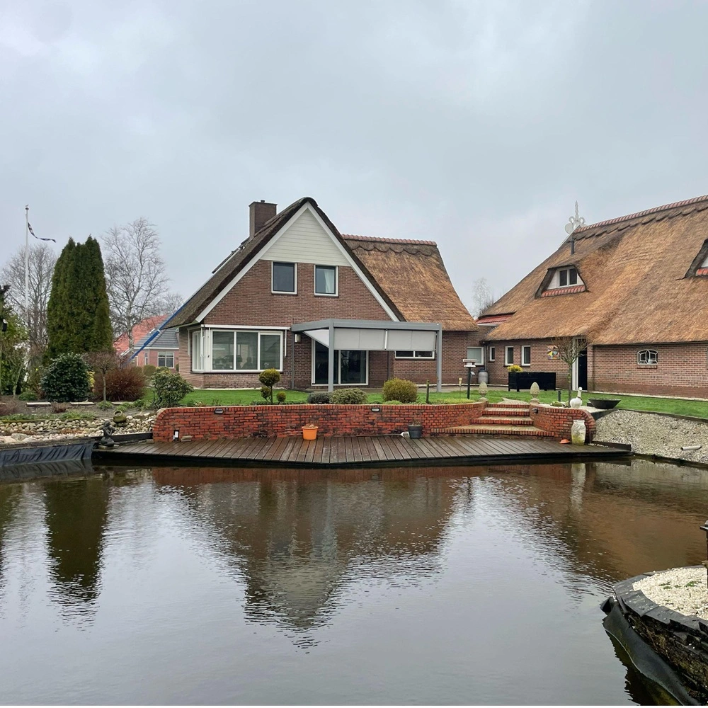 Veldman Zonwering textieloverkapping bij rietgedekte woning aan het water in Ureterp Veldman Zonwering textieloverkapping bij rietgedekte woning aan het water in Ureterp