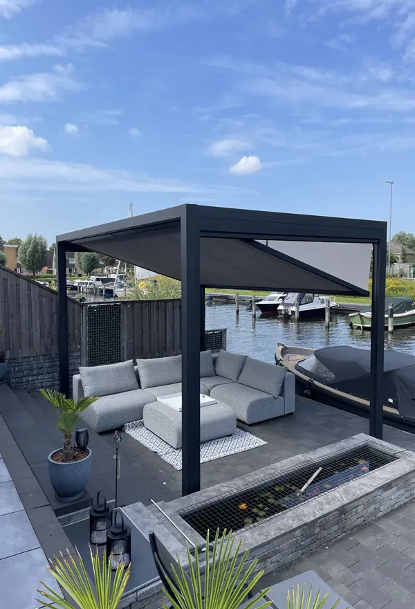 Veldman Zonwering textieloverkapping bij terras aan het water in Scharsterbrug Veldman Zonwering textiel overkapping bij een woning op het Heidemeer in de tuin