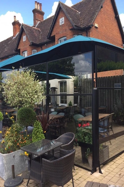 Windscherm met glazen panelen op een terras bij een historisch pand Windscherm met glazen panelen op een terras bij een historisch pand