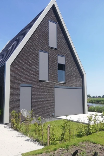 Woning met Zipscreen VZ-R op ramen en terras naast het water Woning met Zipscreen VZ-R op ramen en terras naast het water