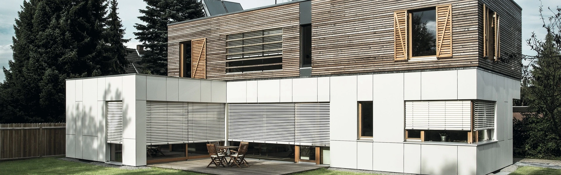 Woning met houten gevel en witte buitenjaloezie Modullo op de begane grond