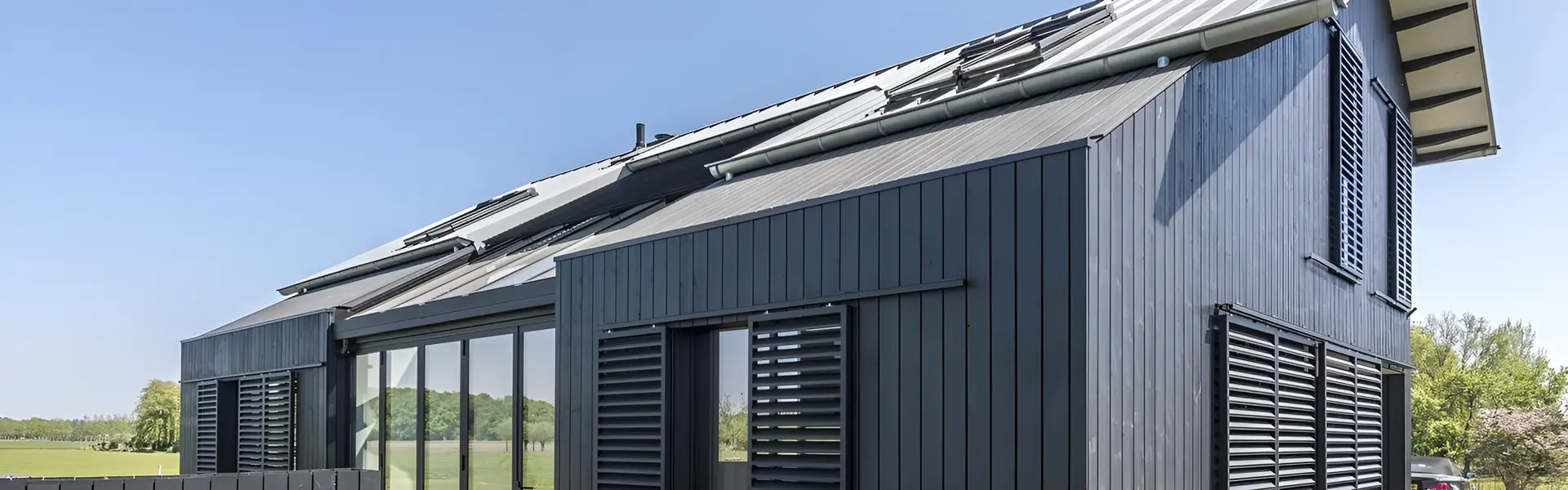 Woning met zwarte houten gevelbekleding en schuifbare houten shutters