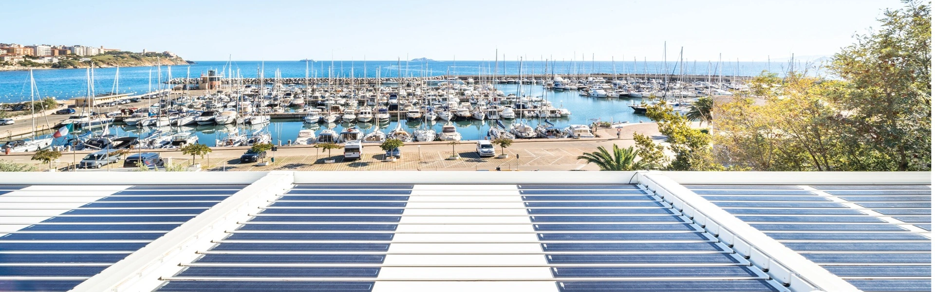 Zonne-energie pergola met uitzicht op een haven vol jachten en blauwe zee