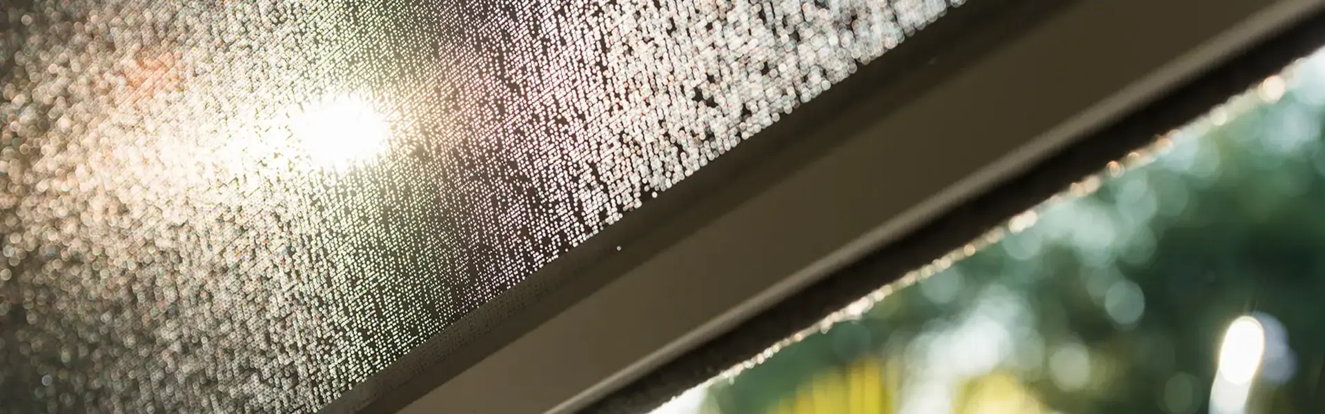 Zonwerend doek met lichtdoorlatend patroon en zonnige achtergrond