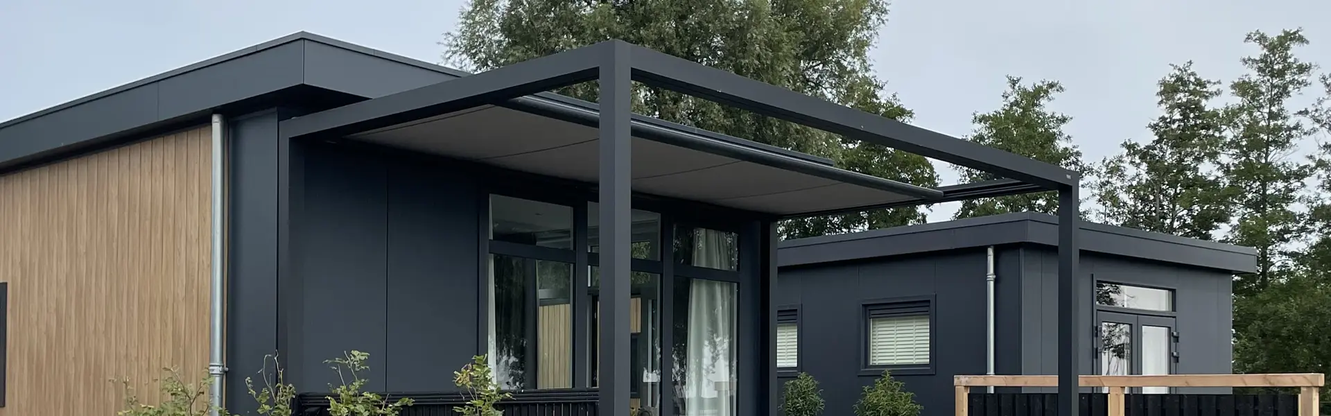 Zonwering op staanders met strakke lijnen en houten gevelbekleding