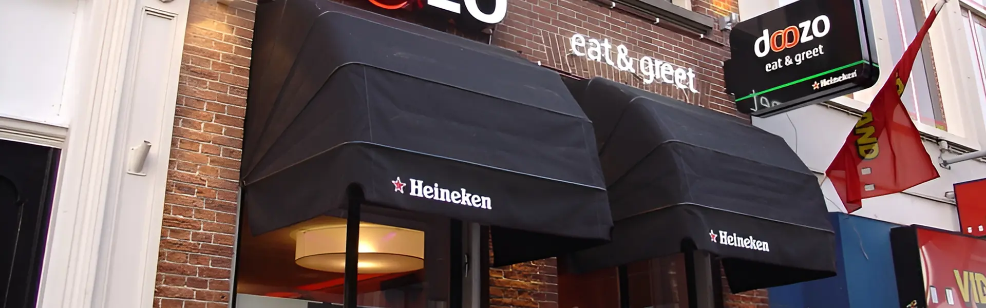 Zwarte markiezen bij Dozo restaurant met opvallend logo en terras