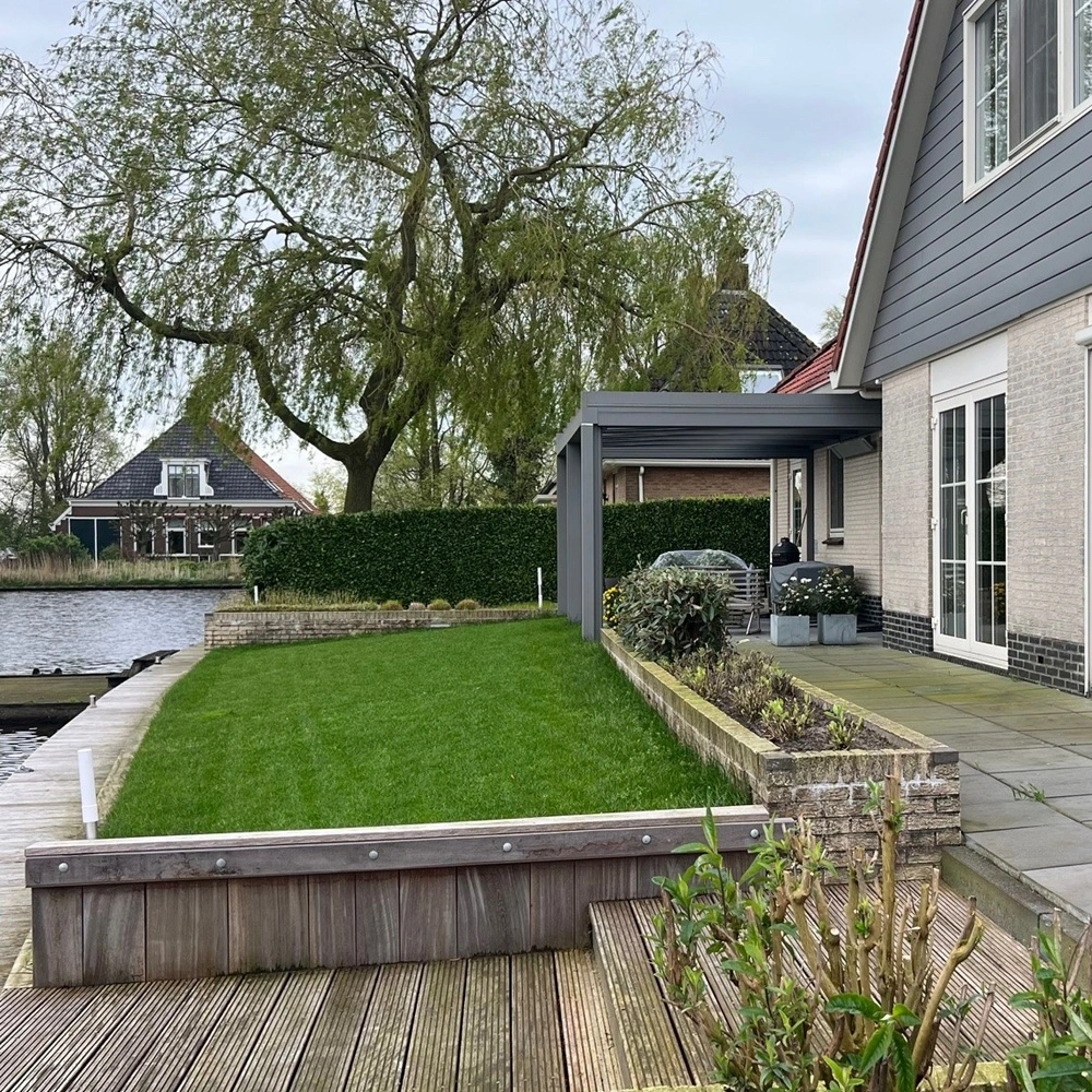 Glazen overkapping aan een woning met tuin en water in Nes Glazen overkapping aan een woning met tuin en water in Nes