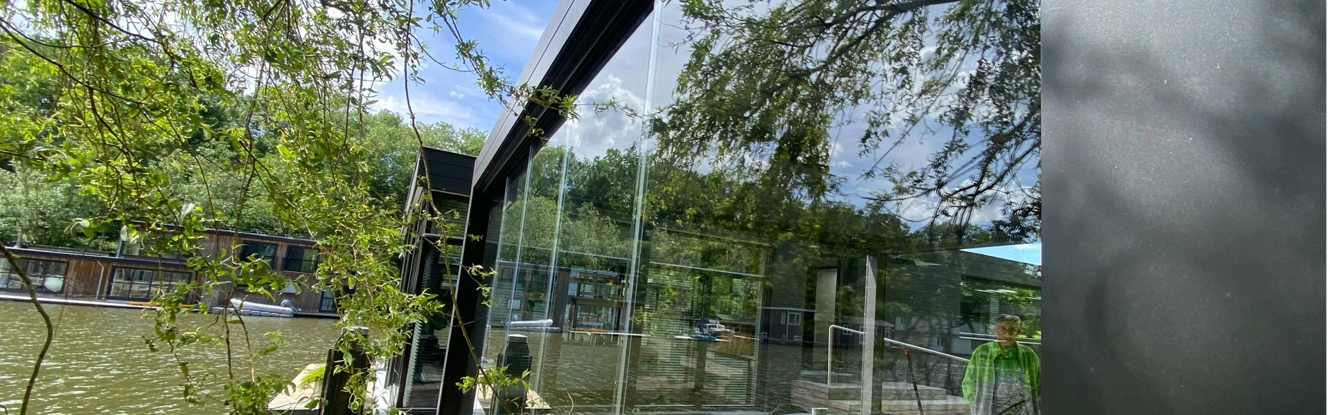 Glazen schuifwand bij watervilla in Amsterdam door Veldman Zonwering