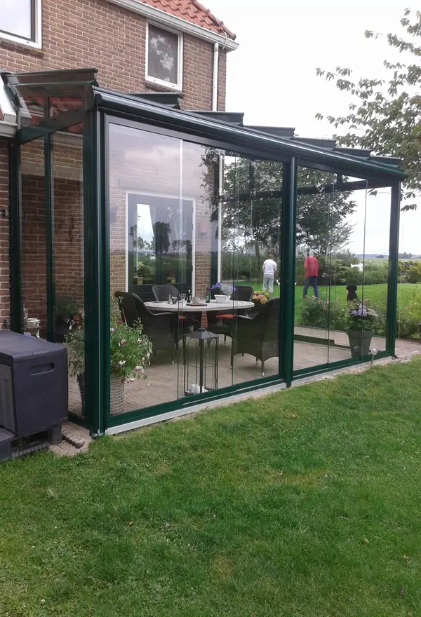 Glazen tuinkamer aan een woning met uitzicht op de tuin geplaatst door Veldman Zonwering Glazen tuinkamer aan een woning met uitzicht op de tuin geplaatst door Veldman Zonwering