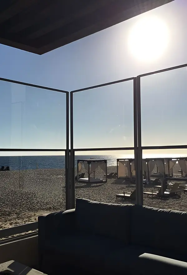 Glazen windscherm in Spanje biedt bescherming op een terras met zeezicht Glazen windscherm in Spanje biedt bescherming op een terras met zeezicht