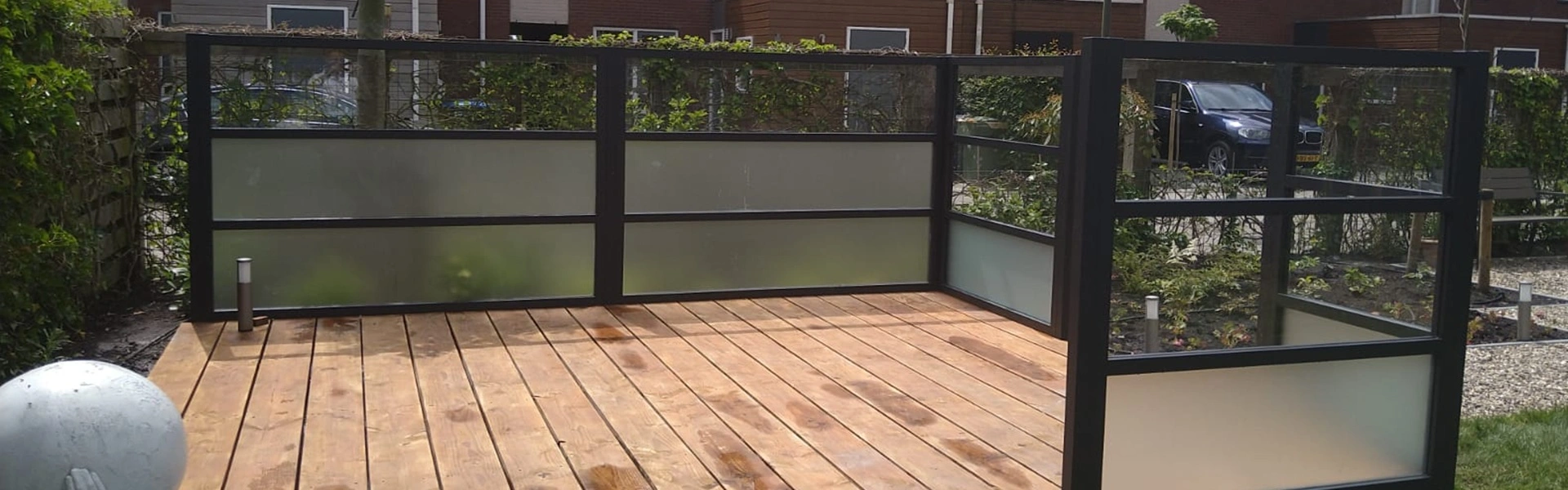 Glazen windscherm op houten terras in Leeuwarden door Veldman Zonwering Glazen windscherm op houten terras in Leeuwarden door Veldman Zonwering