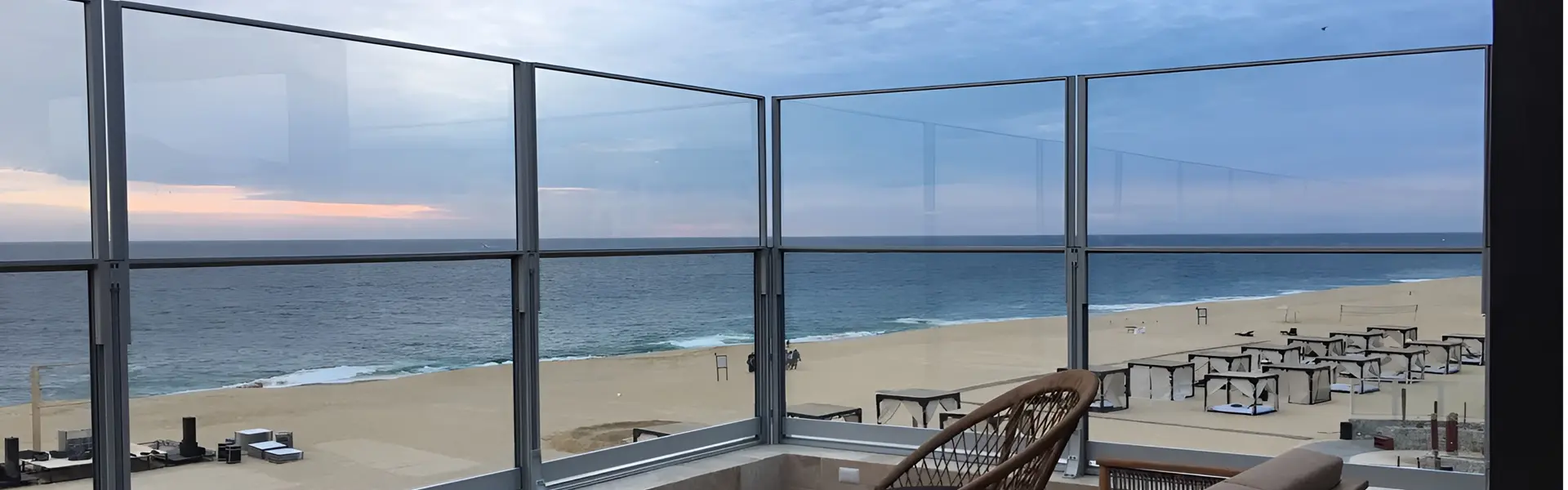 Glazen windschermen op terras in Griekenland met uitzicht op zee en strandbedden. Glazen windschermen op terras in Griekenland met uitzicht op zee en strandbedden.