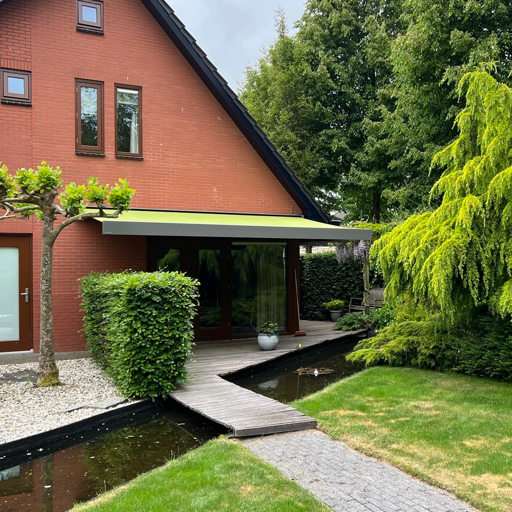 Groen Knikarmscherm in landelijke tuin in Friesland Groen Knikarmscherm in landelijke tuin in Friesland