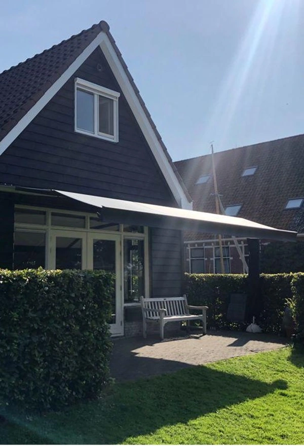 Huis in Broek met modern zon- en regenscherm, gemonteerd door Veldman Zonwering, biedt comfort Huis in Broek met modern zon- en regenscherm, gemonteerd door Veldman Zonwering, biedt comfort