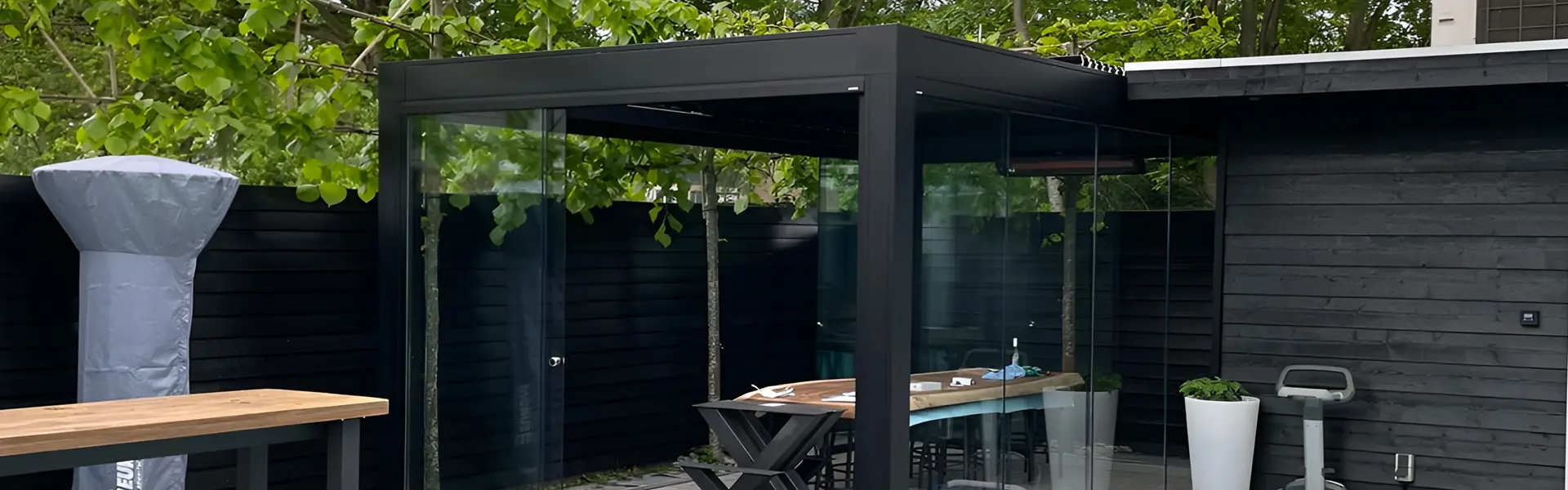 Lamellen tuinkamer met glazen wanden en houten tafel in Amsterdam door Veldman Zonwering