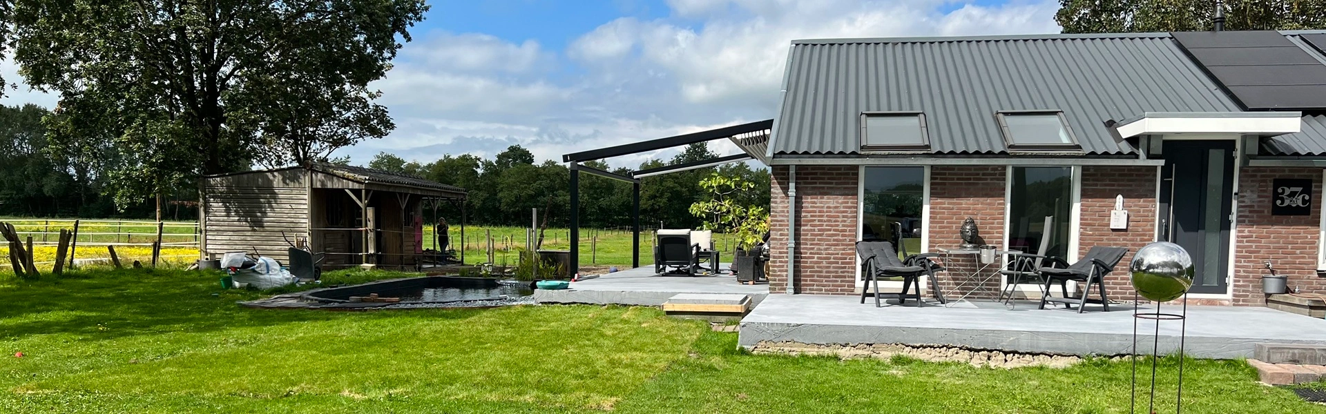 Veldman Zonwering overkapping met schuifdak bij woning in landelijke tuin in Smilde
