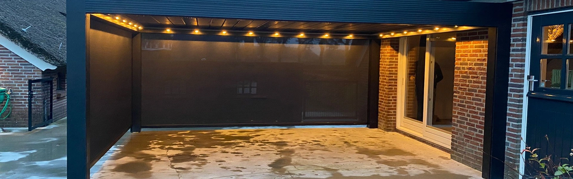 Verlichte terrasoverkapping met zwarte zijschermen in Lieveren door Veldman Zonwering Verlichte terrasoverkapping met zwarte zijschermen in Lieveren door Veldman Zonwering