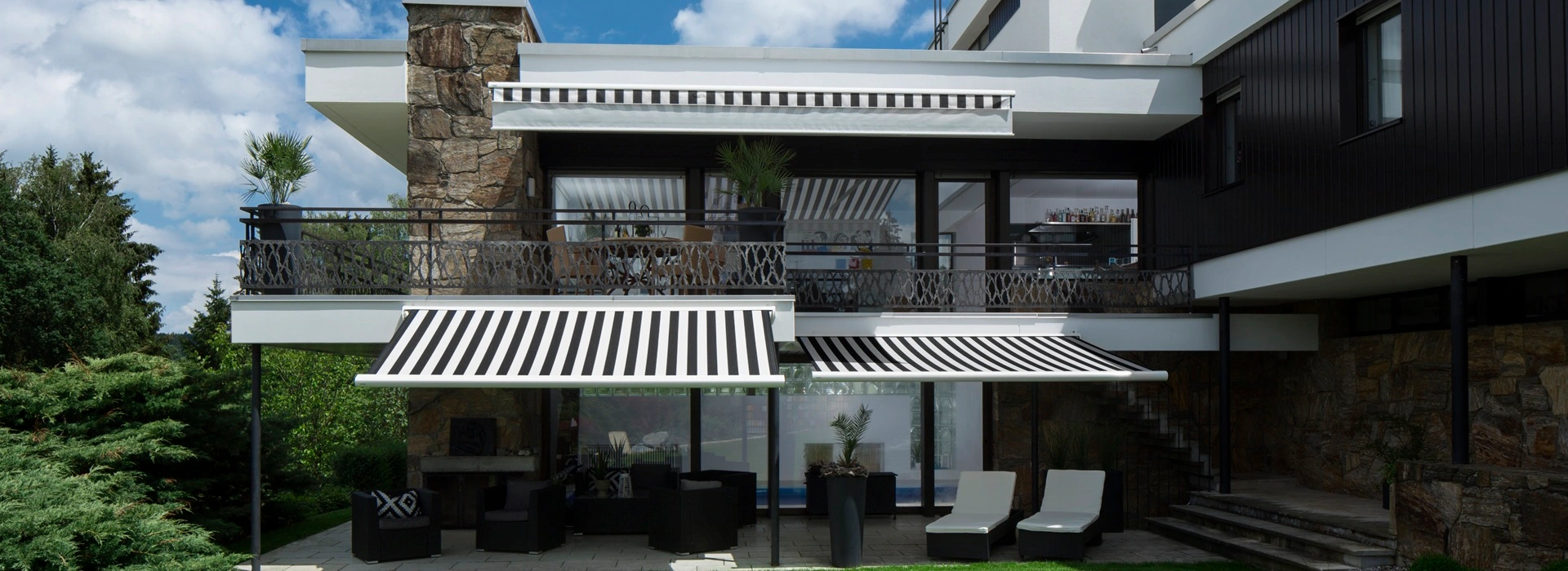 Cassette zonwering FINO met zwart-wit strepen op luxe terras