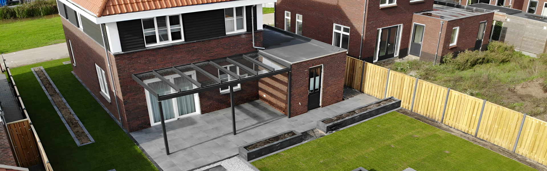 Ruime glazen terrasoverkapping aan moderne hoekwoning – veranda met glazen dak