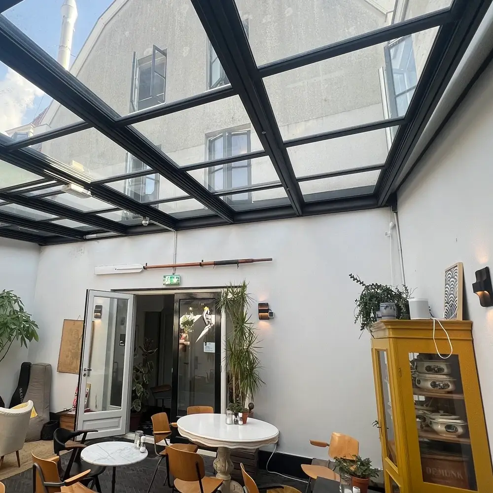 Glazen tuinkamer met schuifdak door Veldman Zonwering in Haarlem bij horeca